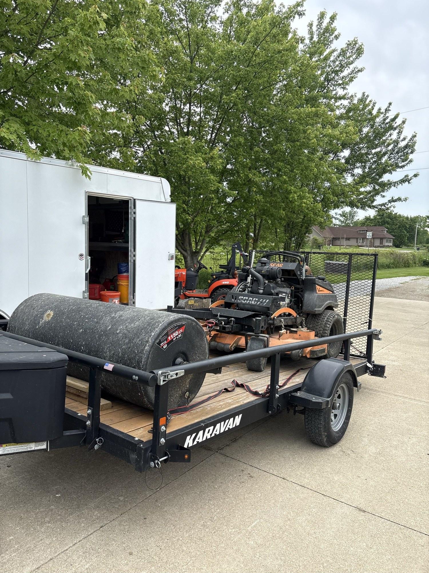 Commercial zero-turn mower loaded on a trailer, ready for a mowing job