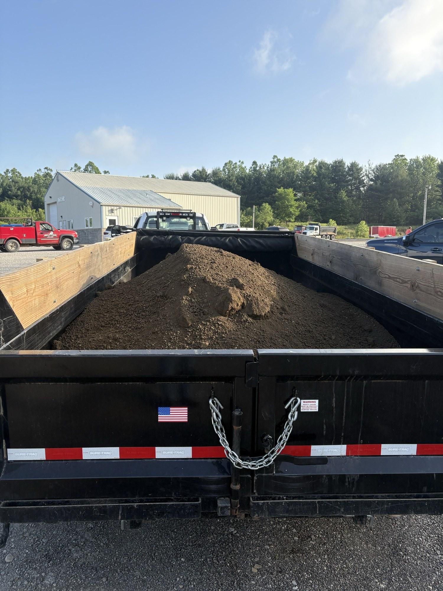 Dump trailer loaded with bulk topsoil ready for delivery